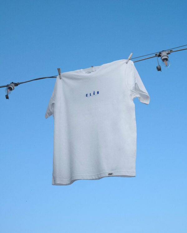 foto maglietta frontale t-shirt bianca con scritta blu su sfondo cielo azzurro